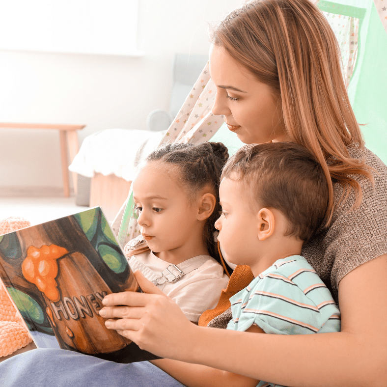a mother reading a book to her children