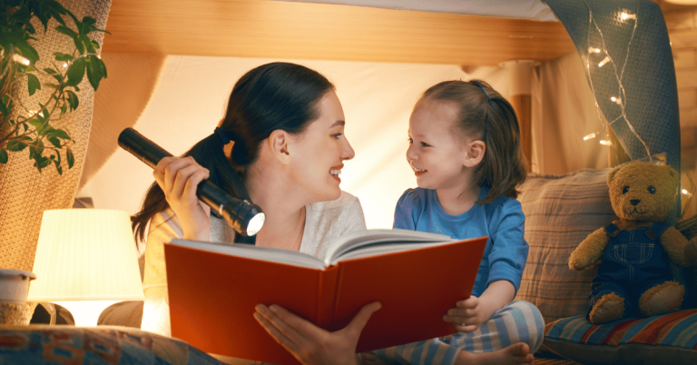 A mom and daughter reading a book as part of their bedtime routine