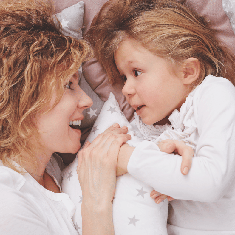 a mother telling stories to her daughter at bedtime